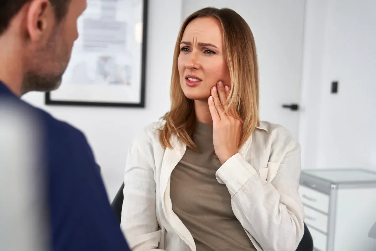 Woman discussing dental concerns with dentist in office setting.