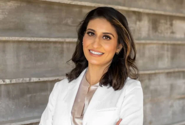 Dr. Ambreen Sandhu smiling in a professional portrait