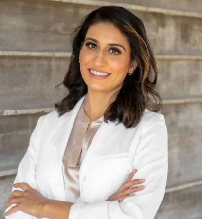 Dr. Ambreen Sandhu standing with her arms crossed outdoors