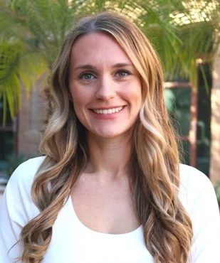 Carly K. smiling in a professional outdoor portrait