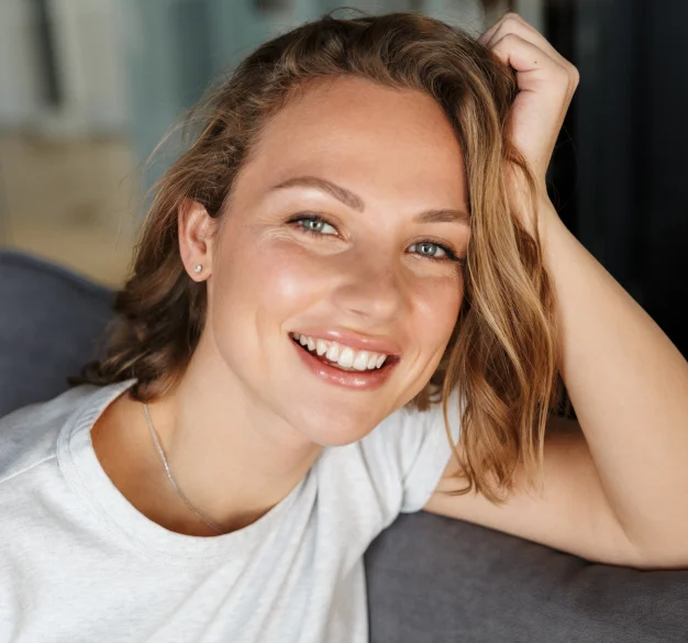Young woman smiling brightly, showcasing healthy teeth and a confident cosmetic dentistry result.