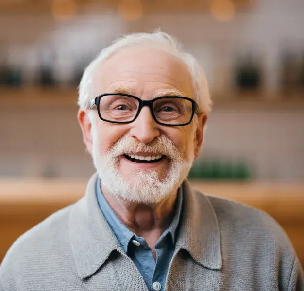 Smiling older man with white beard and glasses in Portland dental office setting.