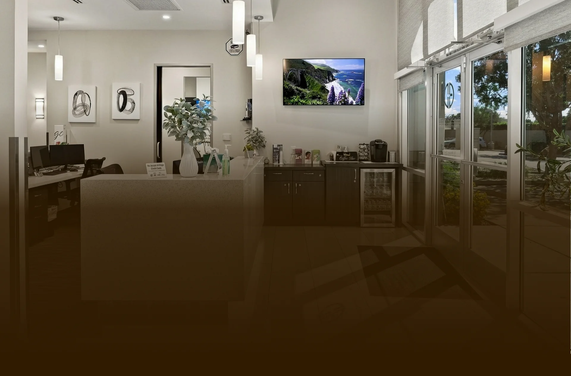 Modern dental treatment area with dental equipment, glass partitions, and bright overhead lighting.