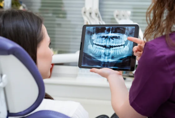 Dental professional reviewing a digital X-ray image